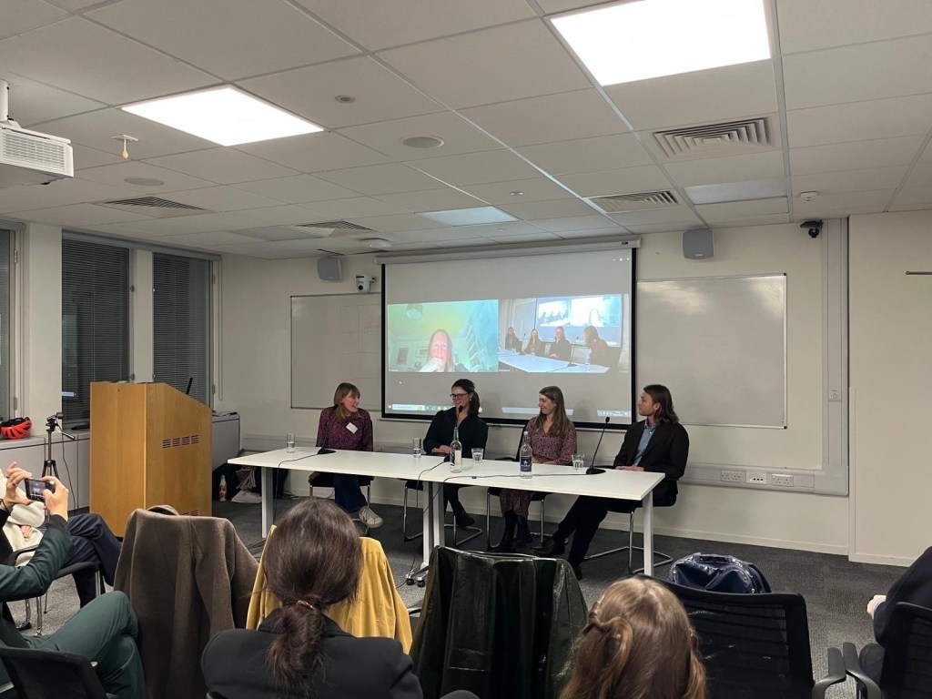 : LVF Stewardship Committee member Harriet Hall hosting a panel event during the December 2024 knowledge session, speaking to panellists Molly Biddell, Isabel Sgambellon, and Henry Parkinson in a room in the Grantham Research Institute. Panellist Dr Juliet Rose appears on screen behind.